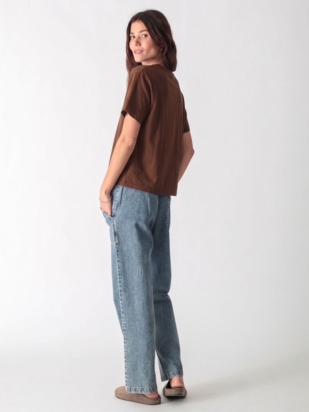 A woman in a brown t-shirt and loose-fit blue cargo jeans