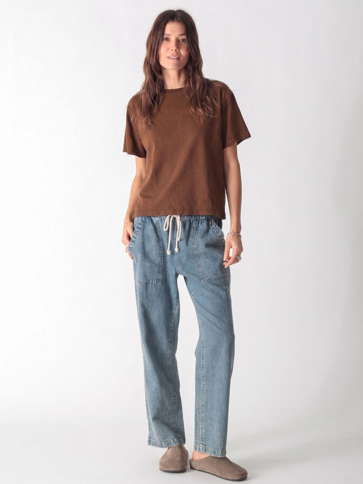 A woman in a brown t-shirt and loose-fit blue cargo jeans