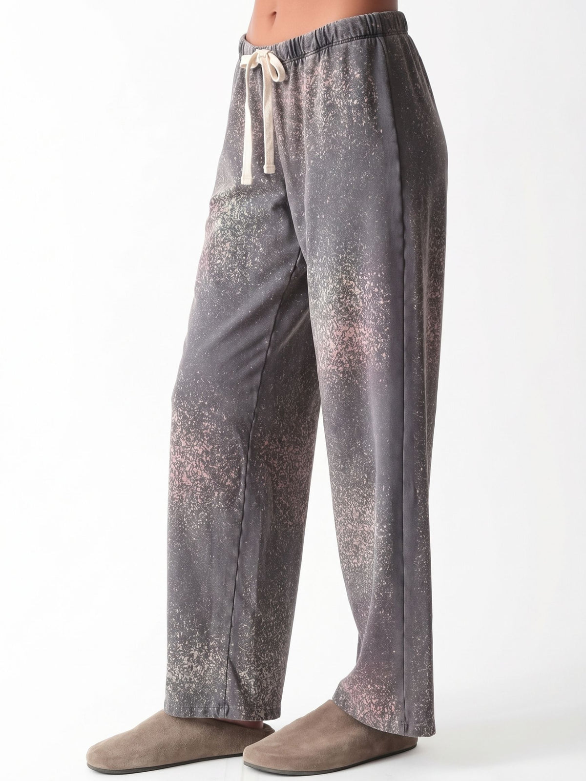 Woman wearing a charcoal gray oversized V-neck French terry sweatshirt with a pink and sage speckled dye print and matching wide-leg sweatpants by Electric & Rose