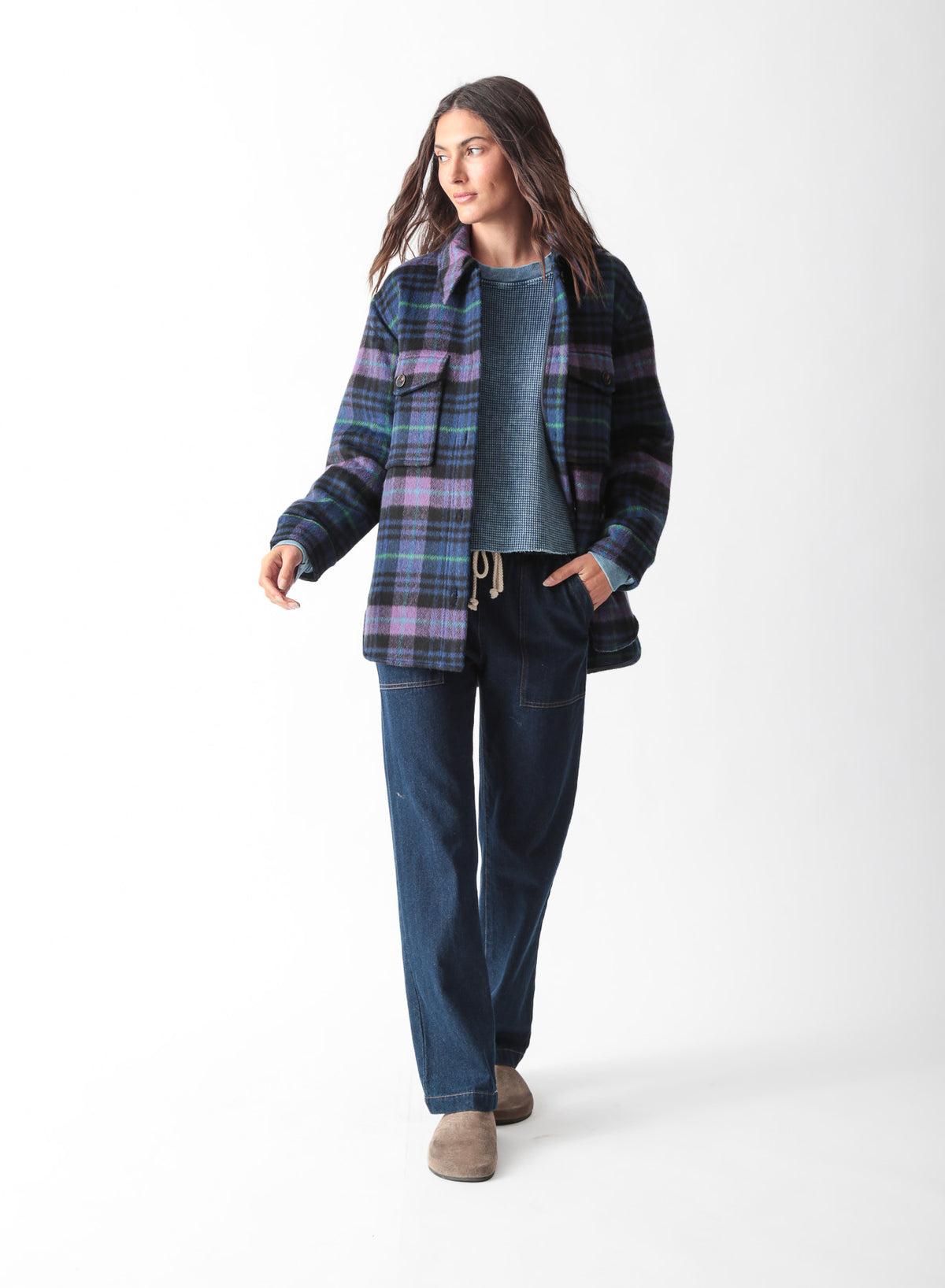 Woman wearing an oversized purple, blue, and black plaid brushed shirt jacket with flap chest pockets, styled with dark wash drawstring jeans, by Electric & Rose