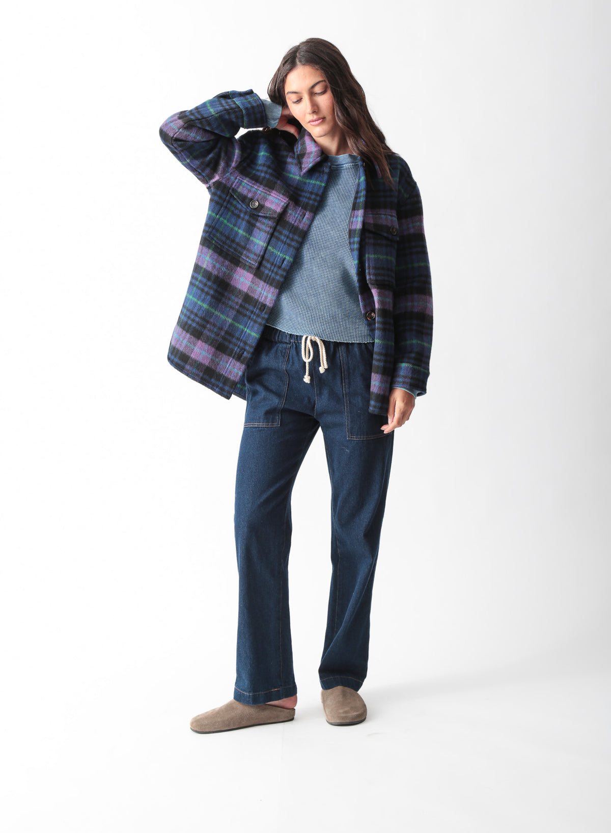 Woman wearing an oversized purple, blue, and black plaid brushed shirt jacket with flap chest pockets, styled with dark wash drawstring jeans, by Electric & Rose