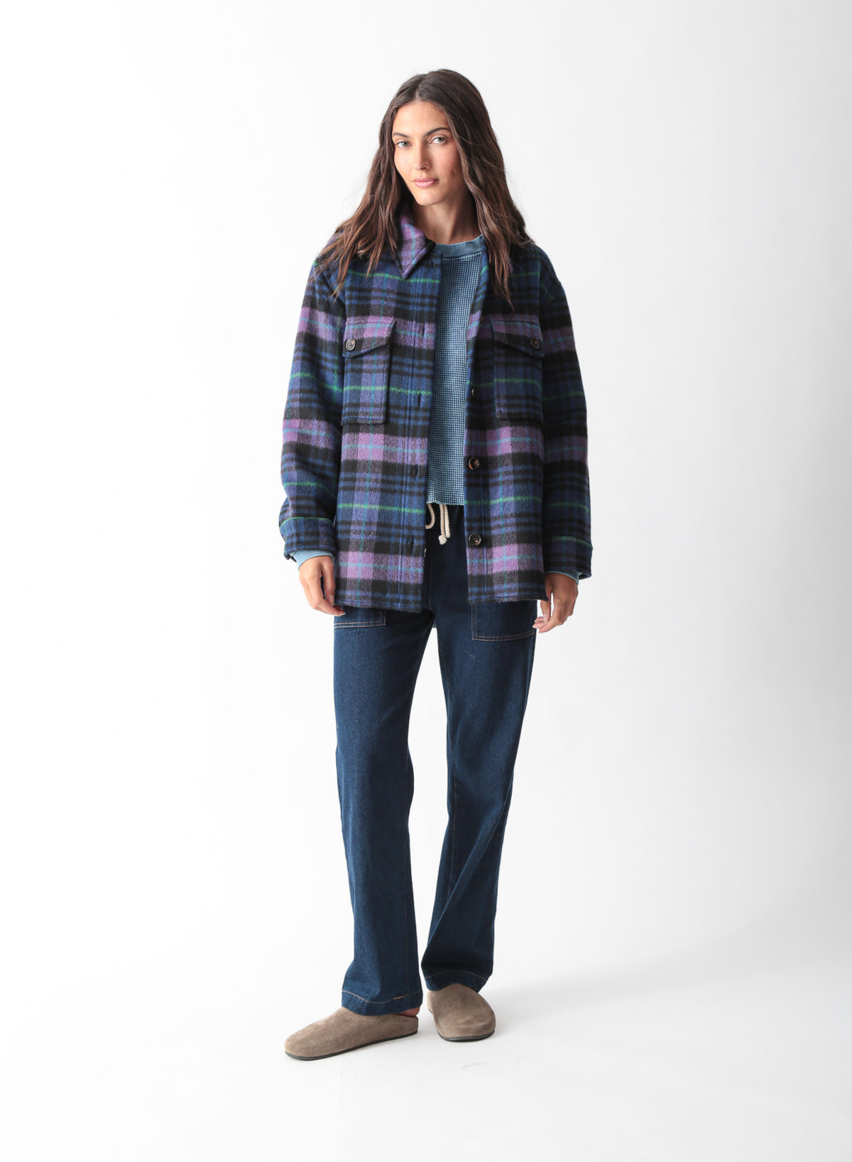 Woman wearing an oversized purple, blue, and black plaid brushed shirt jacket with flap chest pockets, styled with dark wash drawstring jeans, by Electric & Rose
