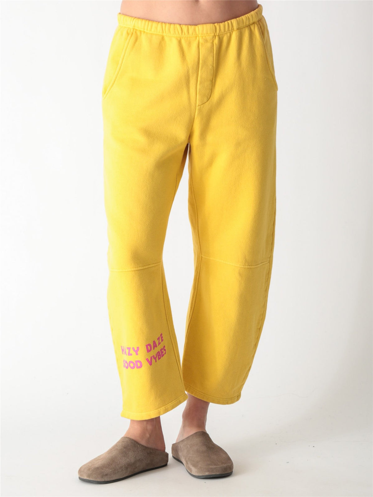 Yellow wide-leg fleece sweatpants featuring an elastic waistband, side pockets, and knee panel seam details.