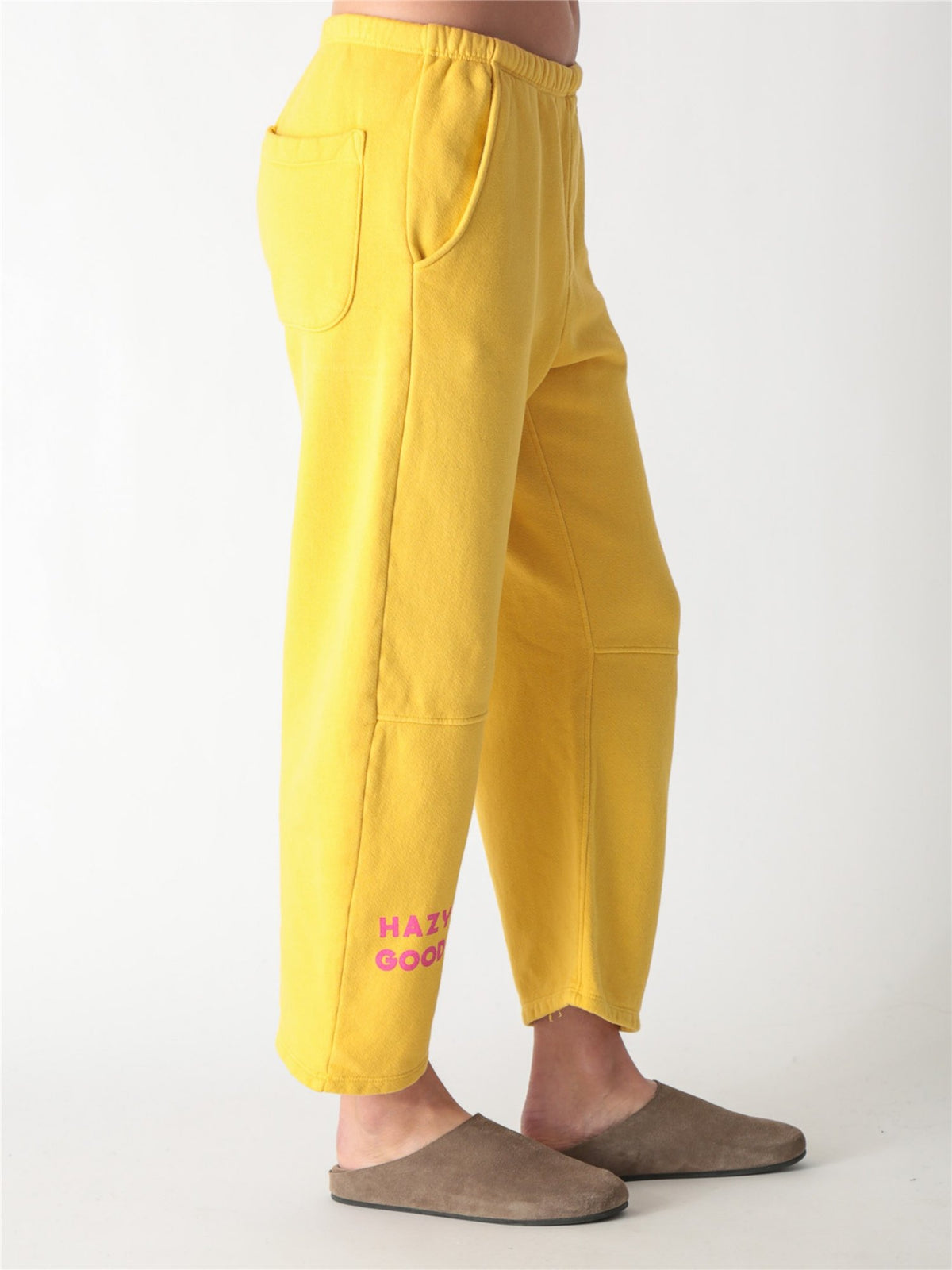 Yellow wide-leg fleece sweatpants featuring an elastic waistband, side pockets, and knee panel seam details.
