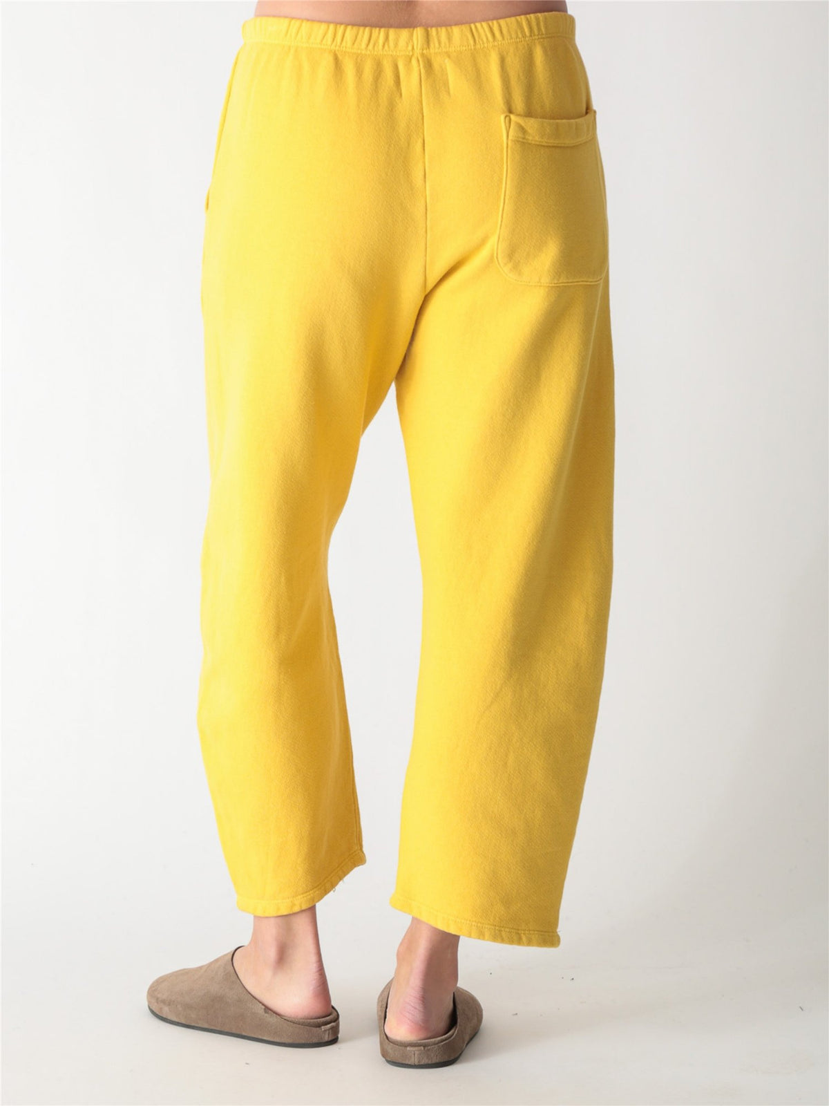 Yellow wide-leg fleece sweatpants featuring an elastic waistband, side pockets, and knee panel seam details.