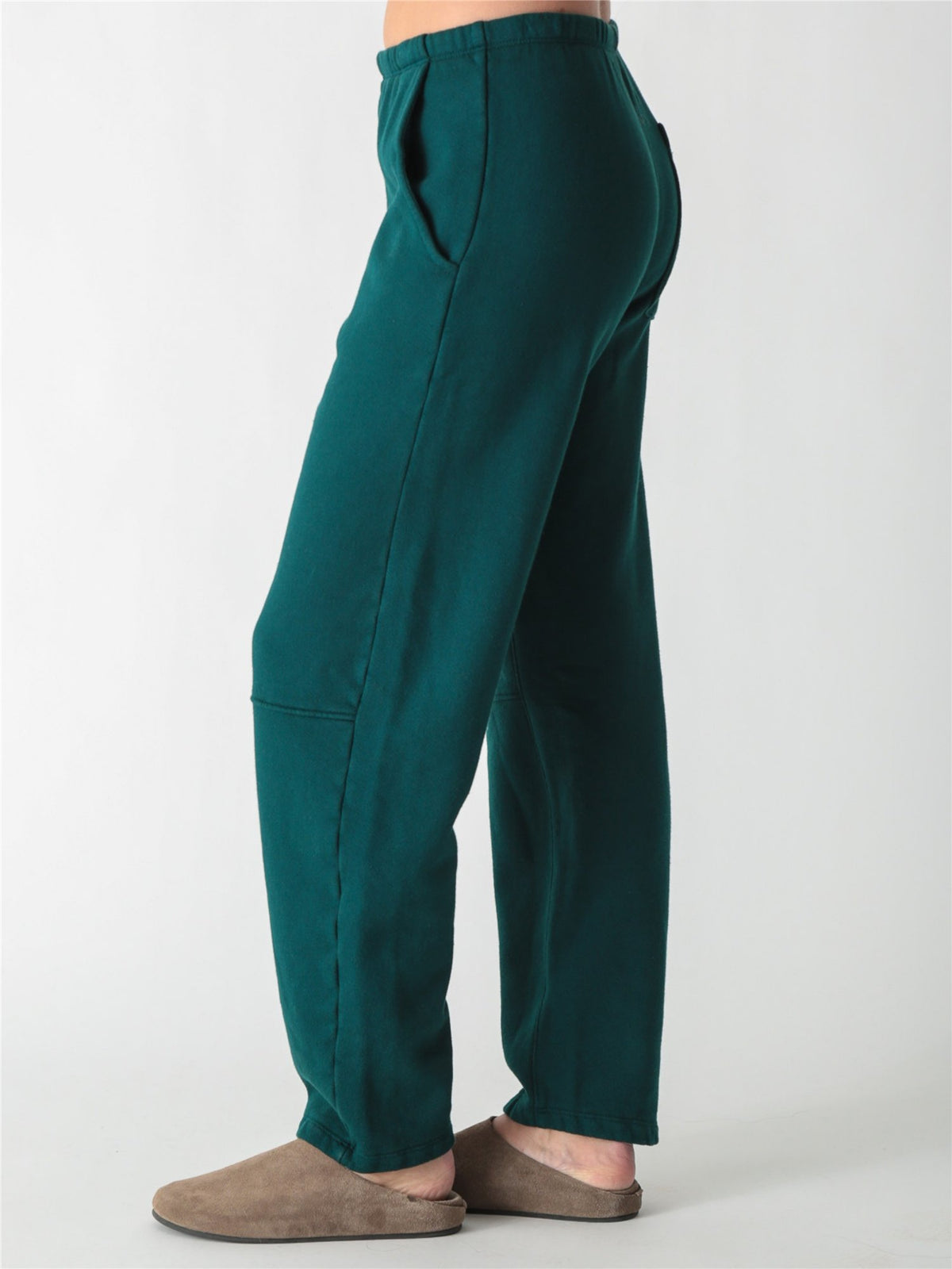 Dark teal green wide-leg fleece sweatpants featuring an elastic waistband, side pockets, and knee panel seam details.