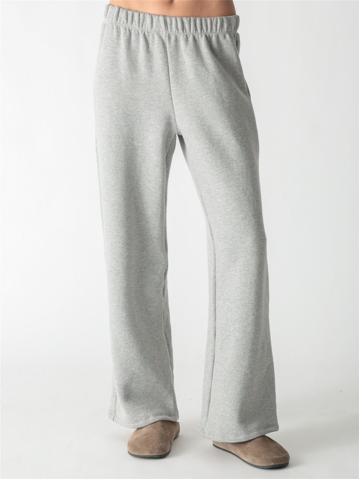 A woman wearing a heather gray cropped zip-up hoodie with voluminous sleeves and matching wide-leg sweatpants against a white background.
