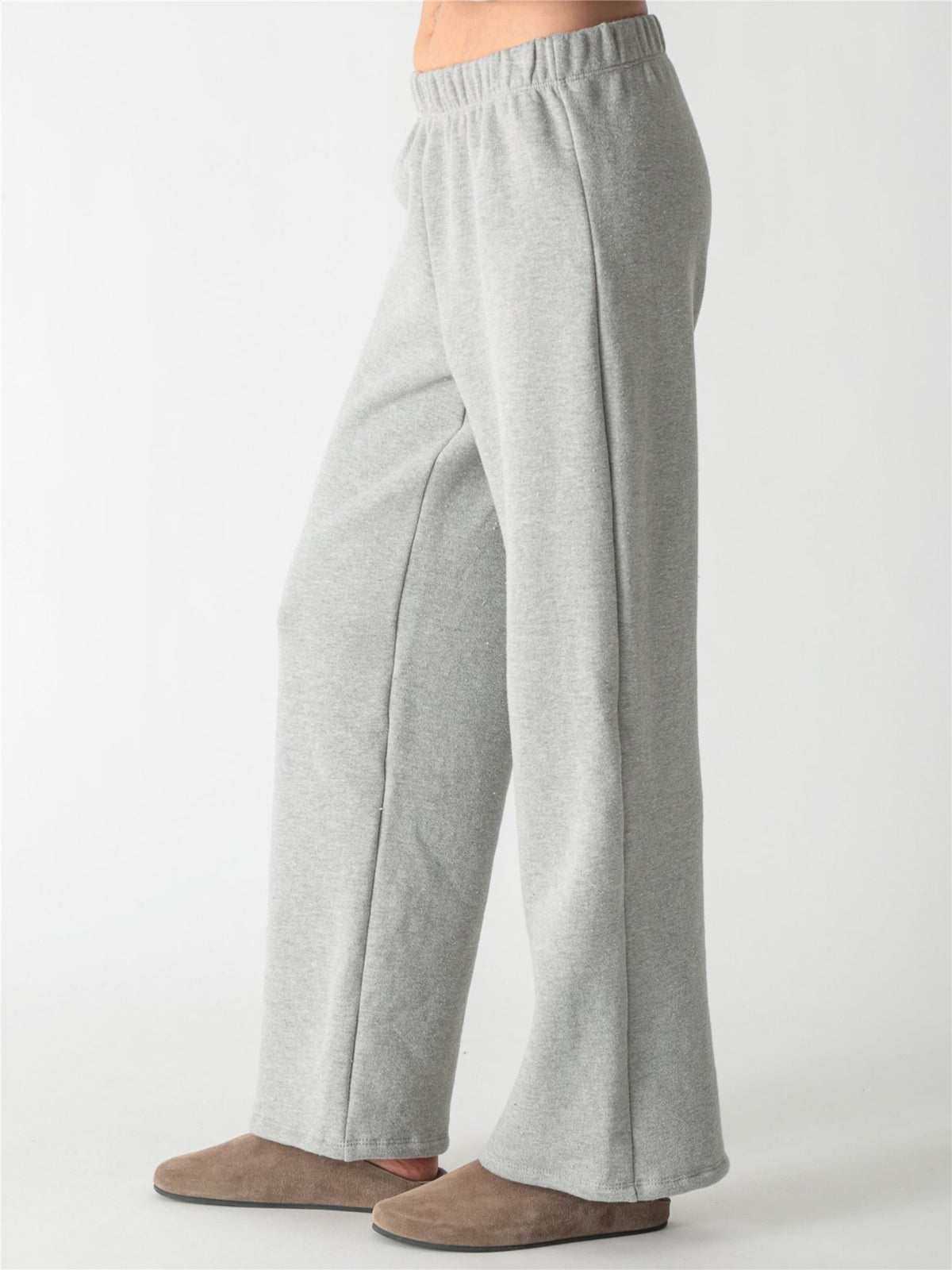 A woman wearing a heather gray cropped zip-up hoodie with voluminous sleeves and matching wide-leg sweatpants against a white background.