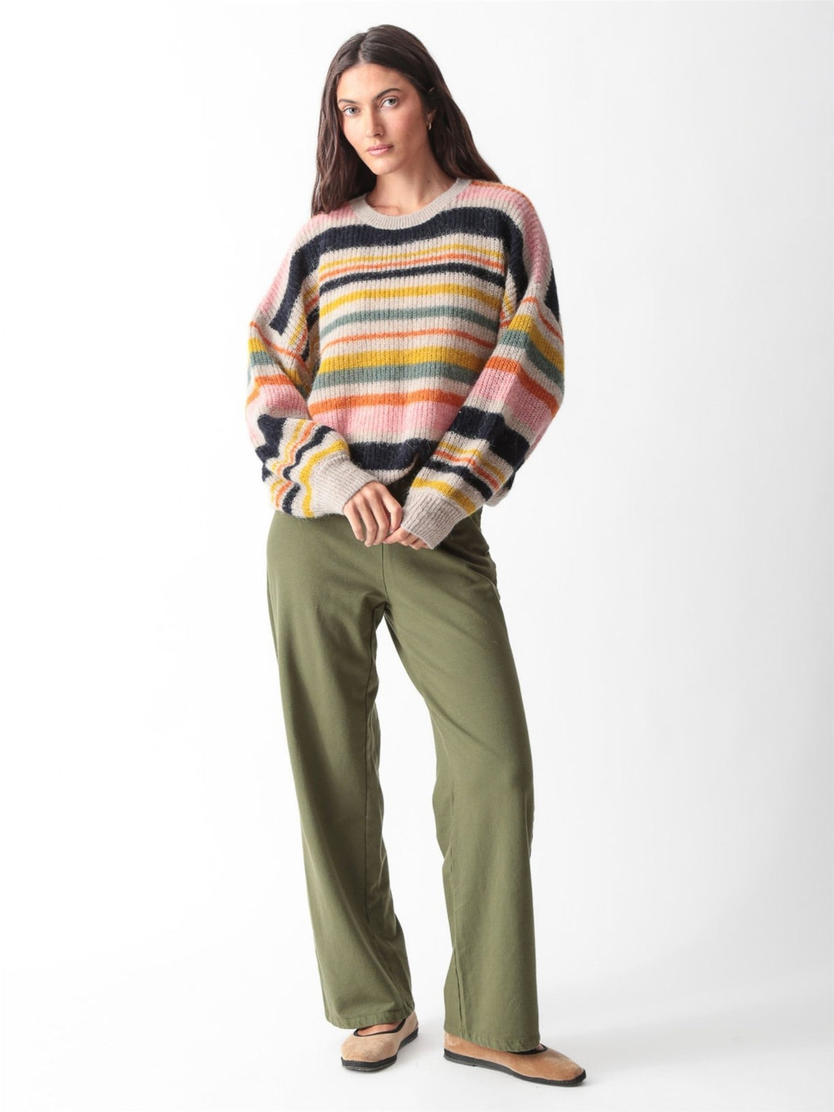 Woman wearing an olive green oversized V-neck sweatshirt with balloon sleeves and matching wide-leg sweatpants by Electric & Rose