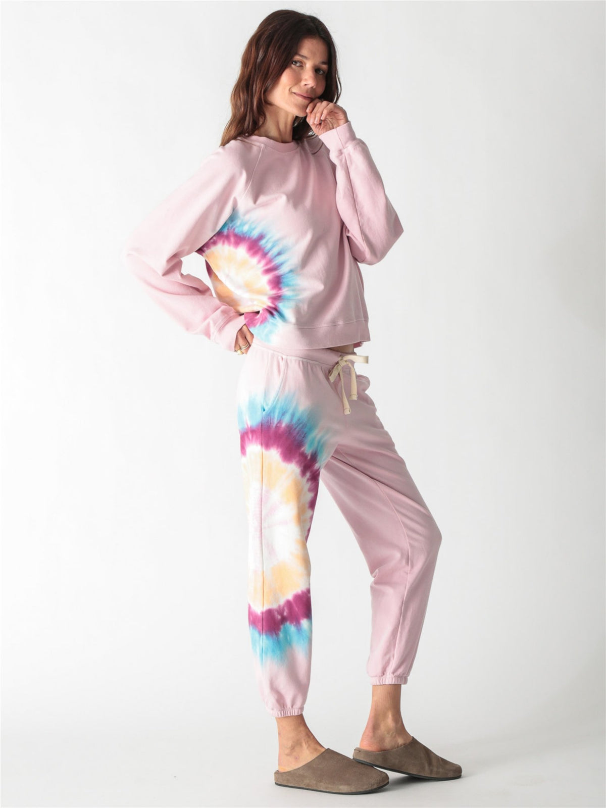A light pink crewneck sweatshirt with long sleeves, ribbed trim, and a colorful tie-dye stripe down the right side.