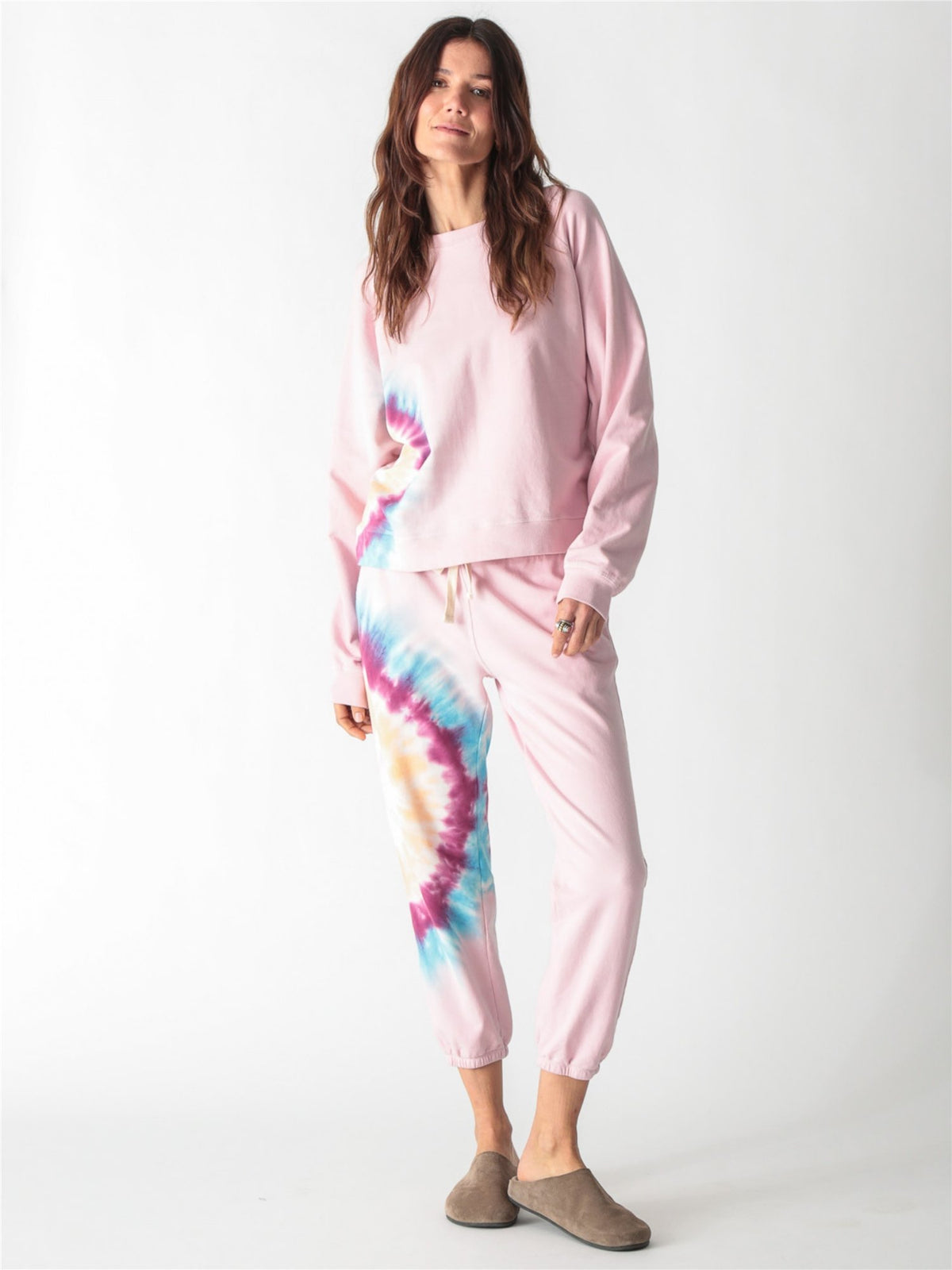 A light pink crewneck sweatshirt with long sleeves, ribbed trim, and a colorful tie-dye stripe down the right side.