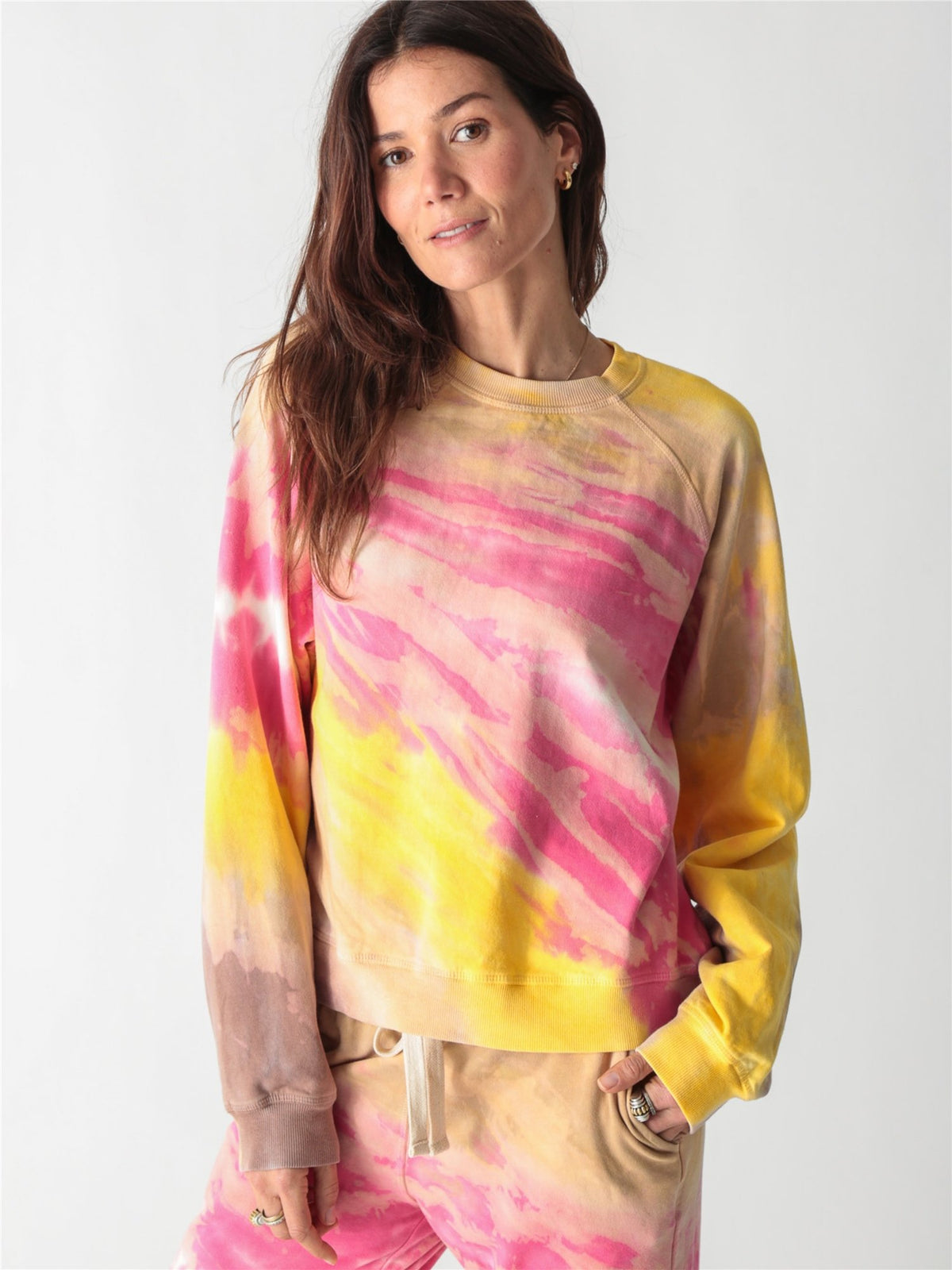 Vibrant pink, yellow, and tan tie-dye crewneck sweatshirt with long relaxed sleeves.