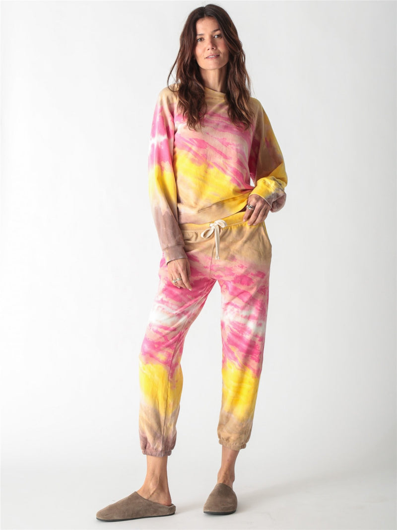 Vibrant pink, yellow, and tan tie-dye crewneck sweatshirt with long relaxed sleeves.