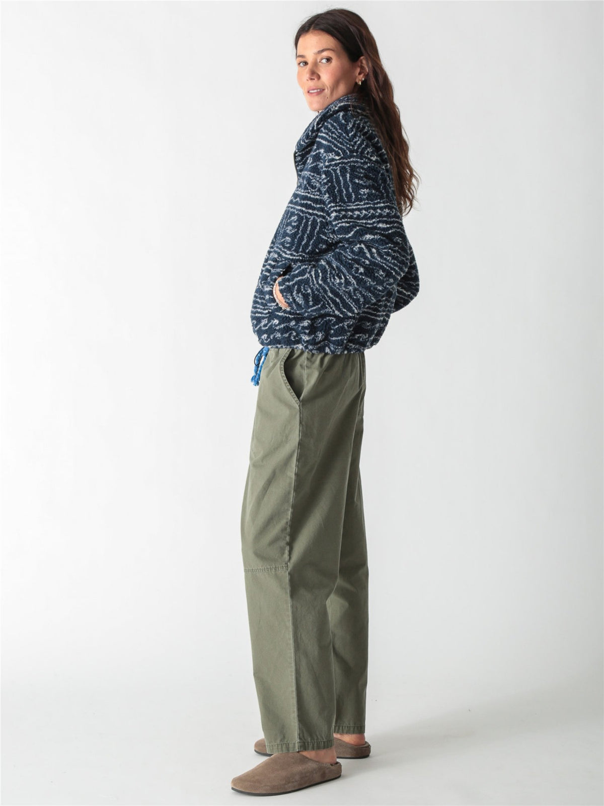 A woman wearing a dark blue and white patterned fleece zip-up jacket paired with drawstring denim jeans against a plain white background.