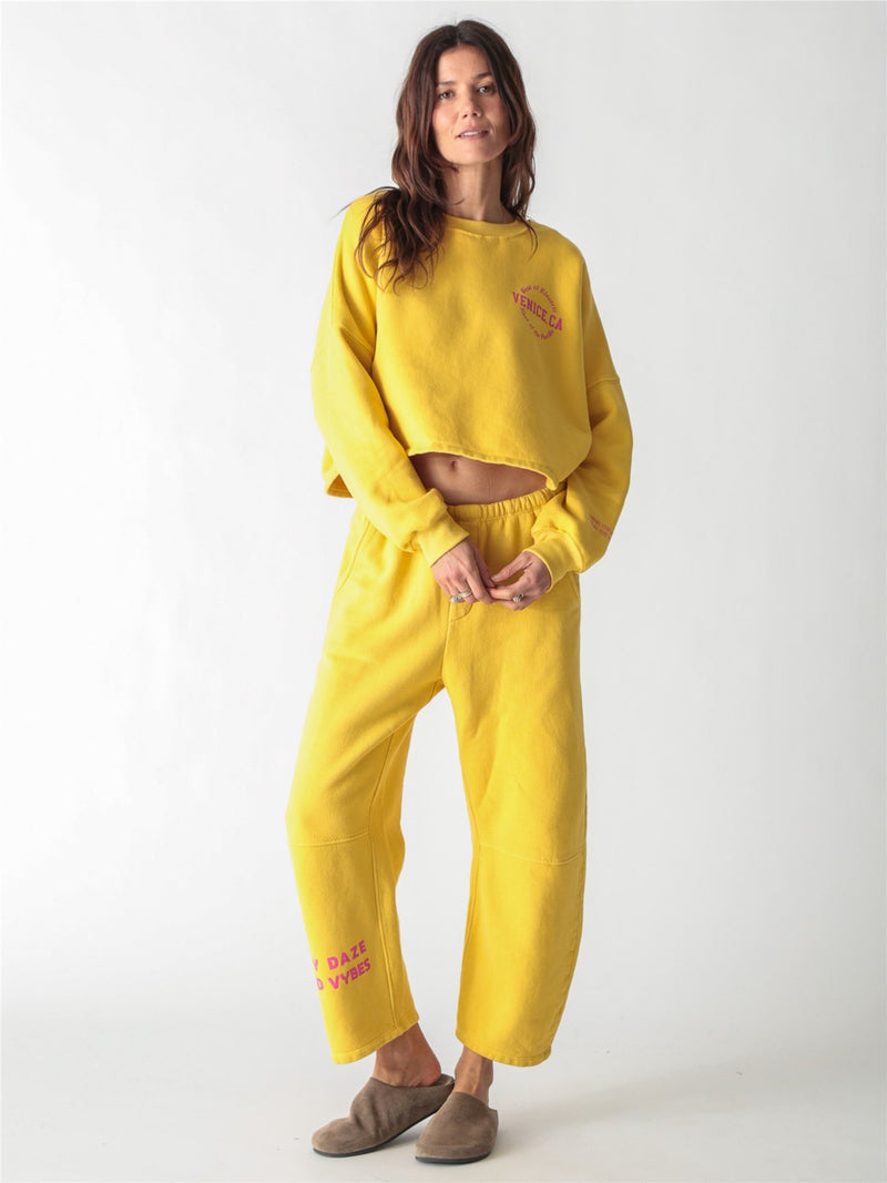 A yellow oversized cropped crewneck sweatshirt with dropped shoulders and ribbed cuffs.