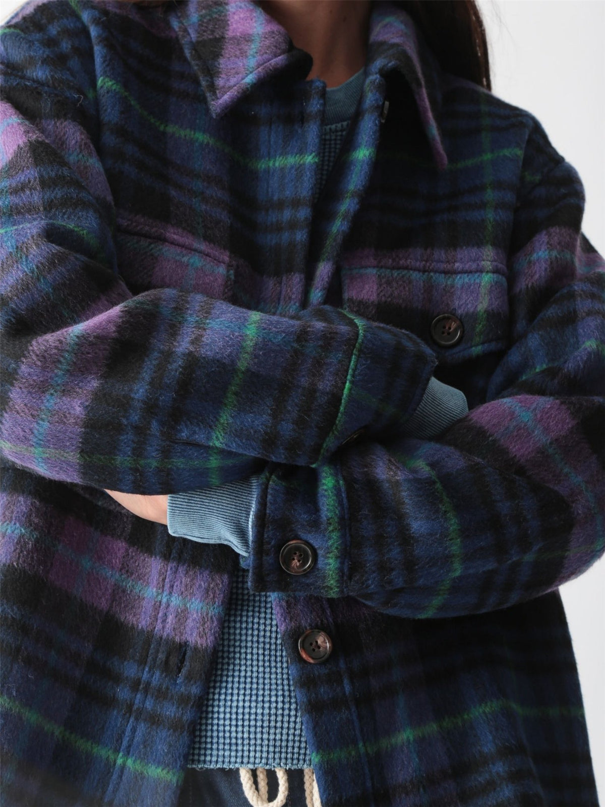 Woman wearing an oversized purple, blue, and black plaid brushed shirt jacket with flap chest pockets, styled with dark wash drawstring jeans, by Electric & Rose