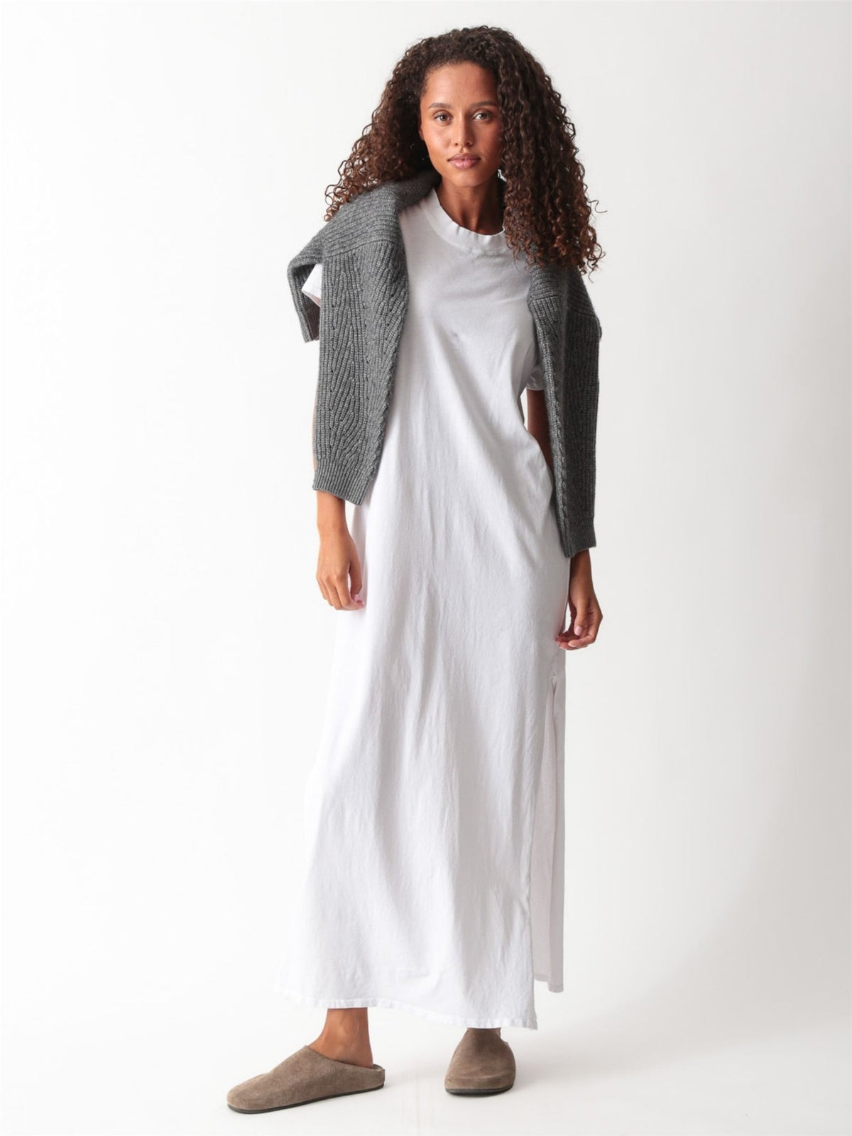 Woman wearing a white cotton jersey maxi T-shirt dress with short cuffed sleeves, crew neck, and side slit by Electric & Rose