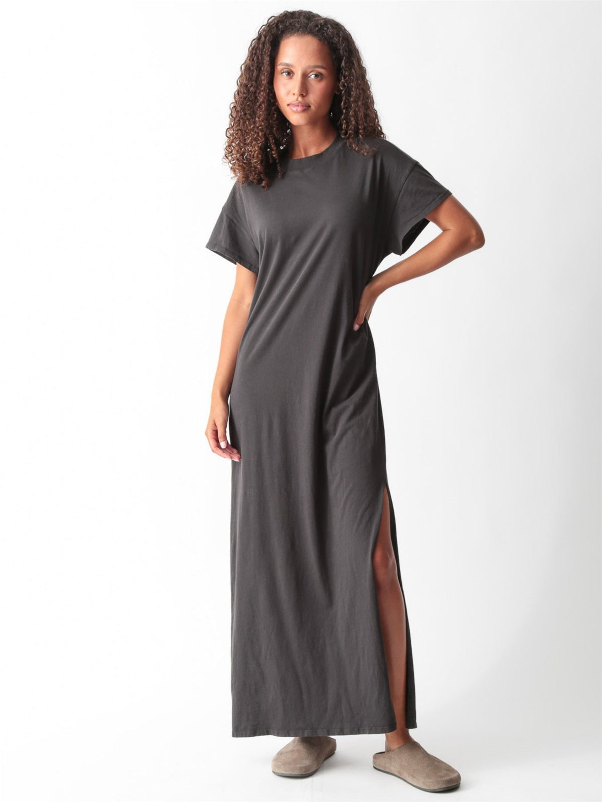 Woman wearing a grey cotton jersey maxi T-shirt dress with short cuffed sleeves, crew neck, and side slit by Electric & Rose