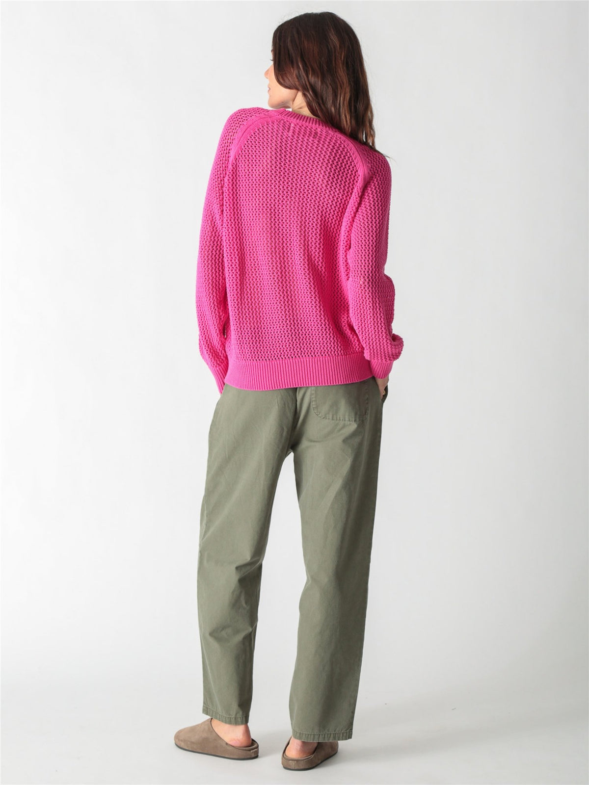Bright pink open-knit crewneck sweater with long wide sleeves and ribbed cuffs.