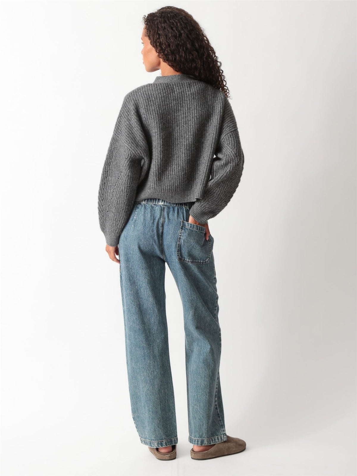 Close-up of a heather gray ribbed-knit cropped V-neck cardigan with tortoiseshell buttons, styled with drawstring denim, by Electric & Rose