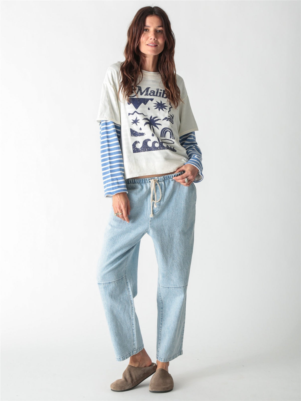 Off-white t-shirt featuring blue "Malibu" script and beach-inspired graphic art printed on the front.