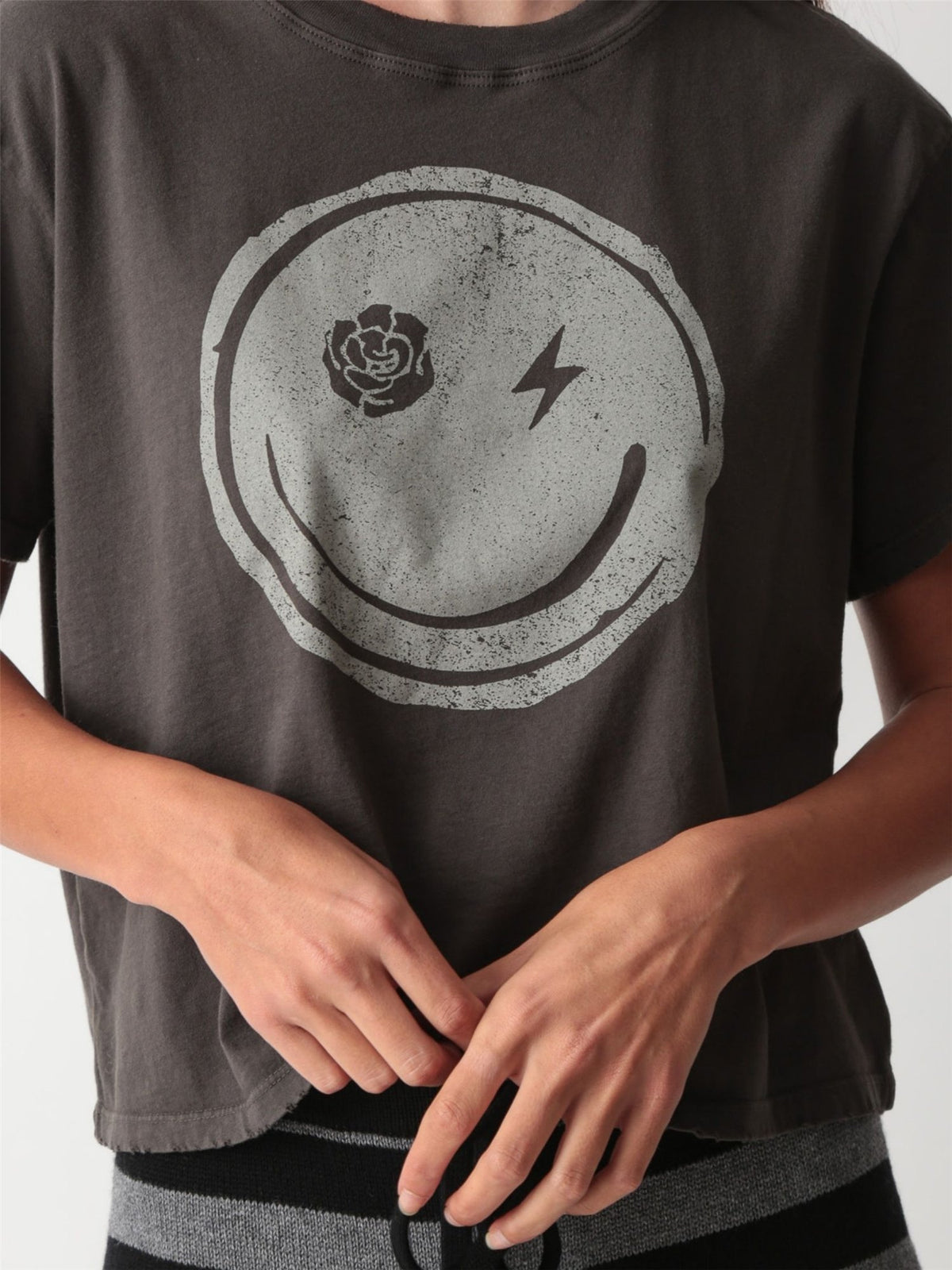 Vintage-wash charcoal graphic tee with a distressed smiley face print featuring a rose and lightning bolt eyes by Electric & Rose