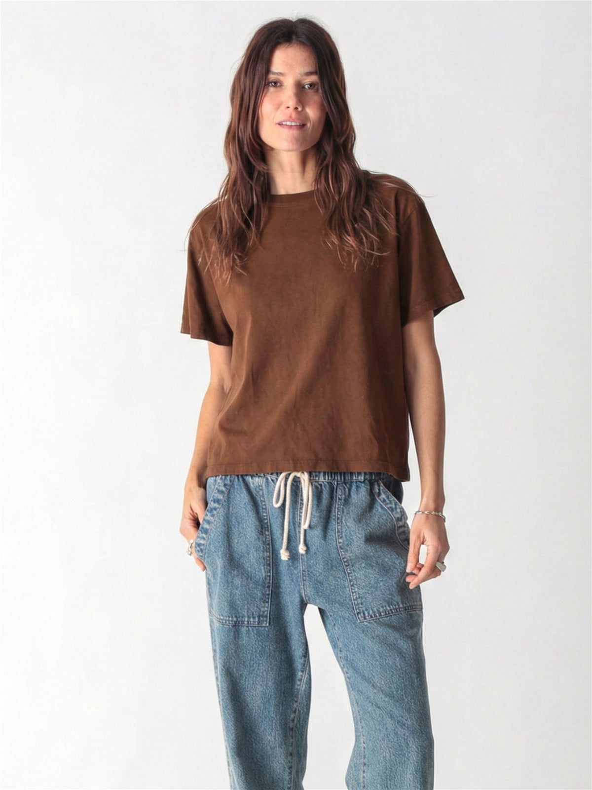 A woman in a brown t-shirt and loose-fit blue cargo jeans