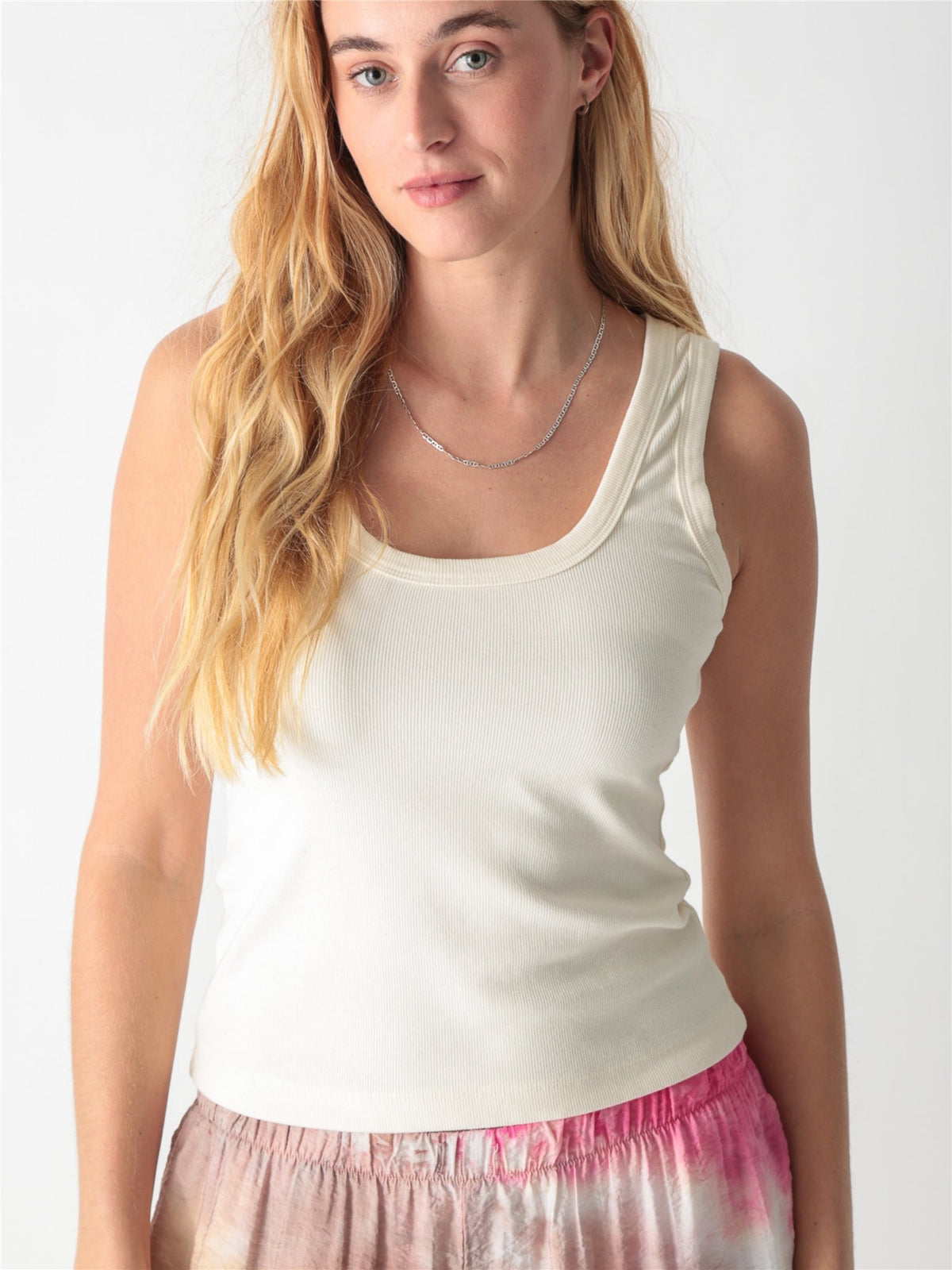 Off-white ribbed tank top with a scoop neckline and thick straps.